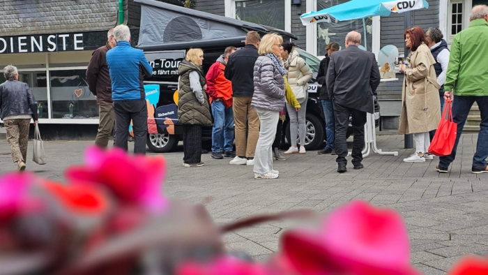 Menschen stehen um ein Auto auf der Straße